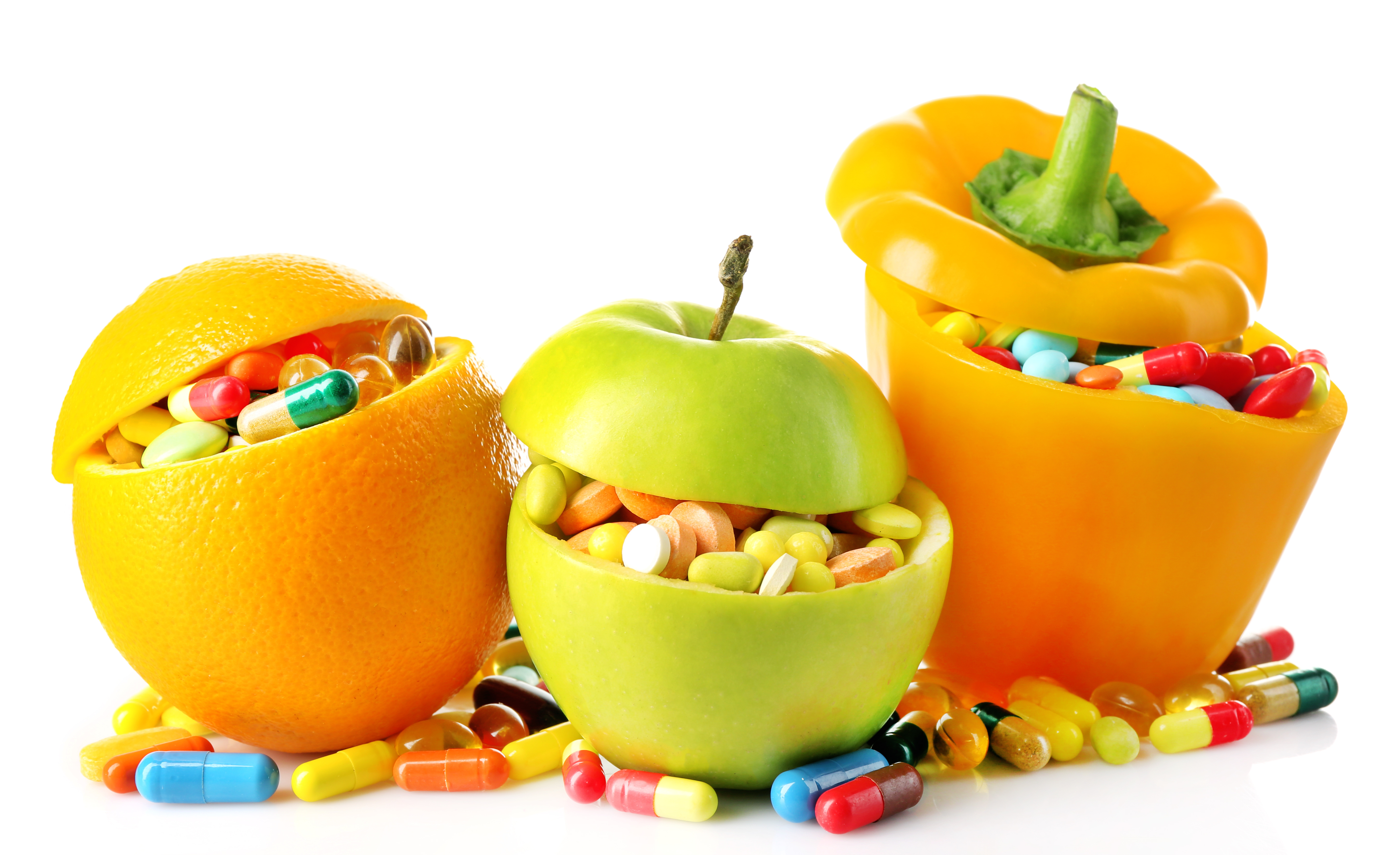 Orange fruit, apple and bell-pepper and colorful pills, isolated on white